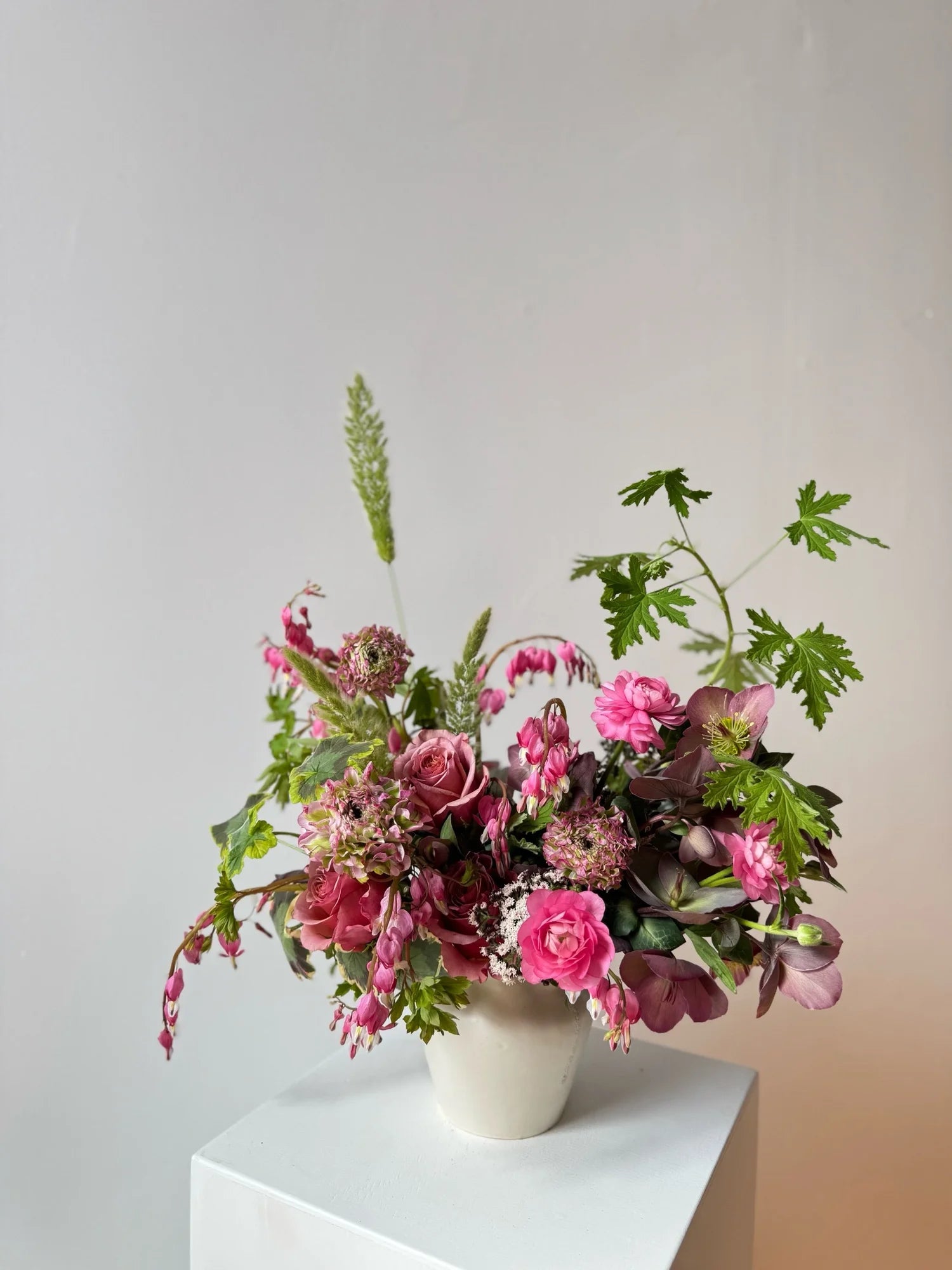 Floral arrangement in a white vase on a light gray background