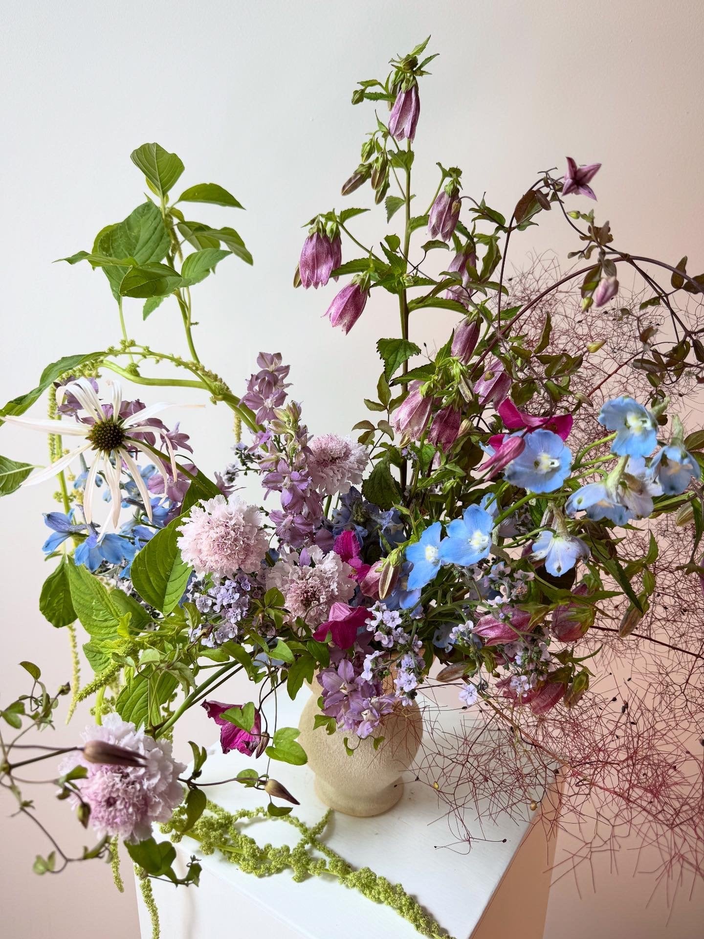 Bouquet of colorful flowers in a vase on a white surface with a blurred background