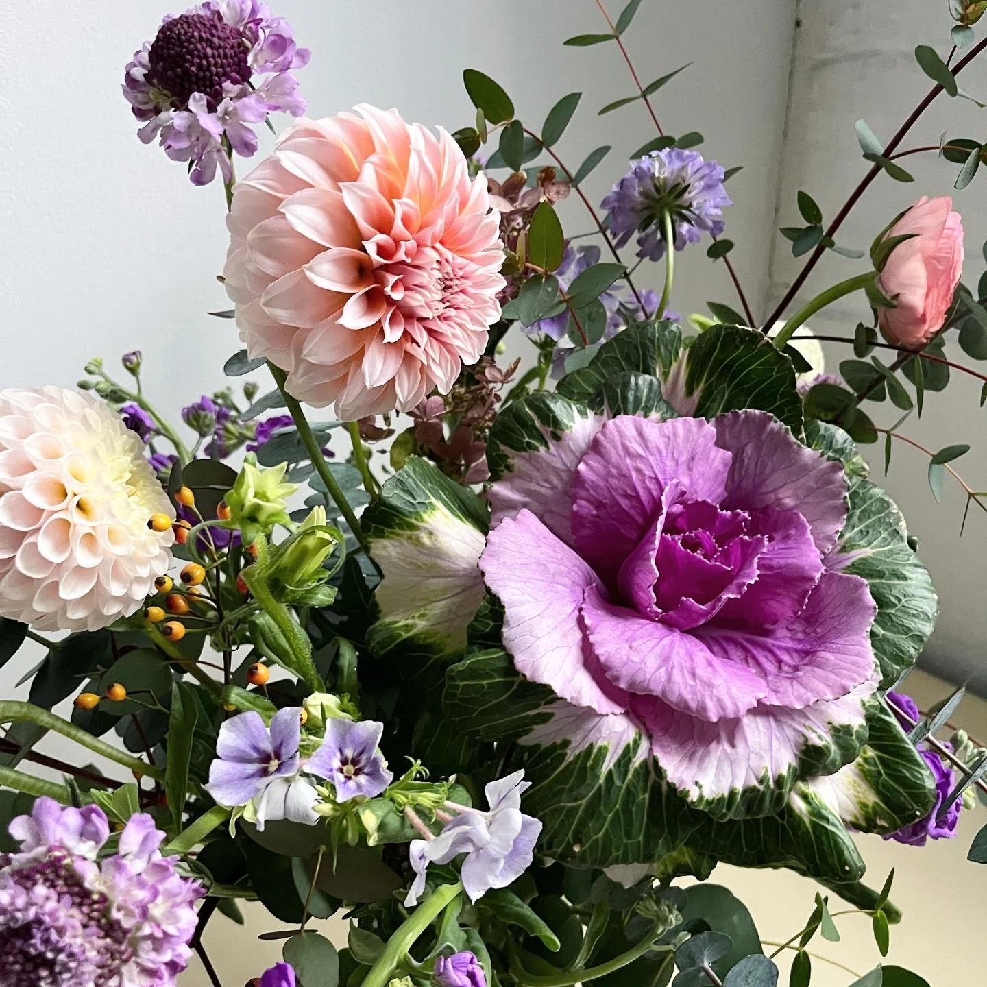 Colorful bouquet of flowers including pink, purple, and green elements.