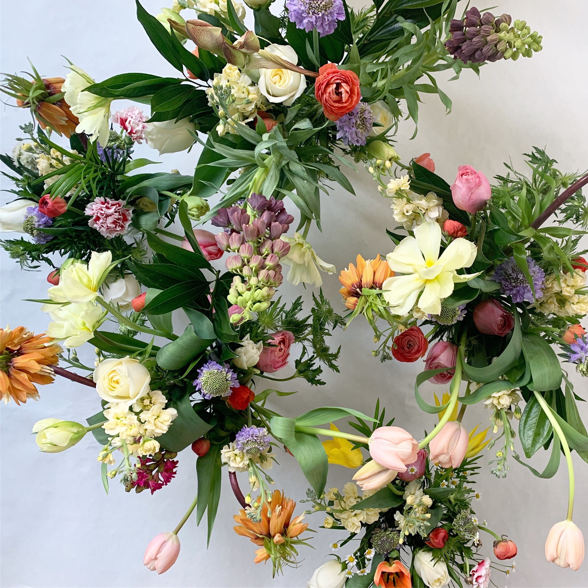 Colorful floral wreath with various flowers on a light background