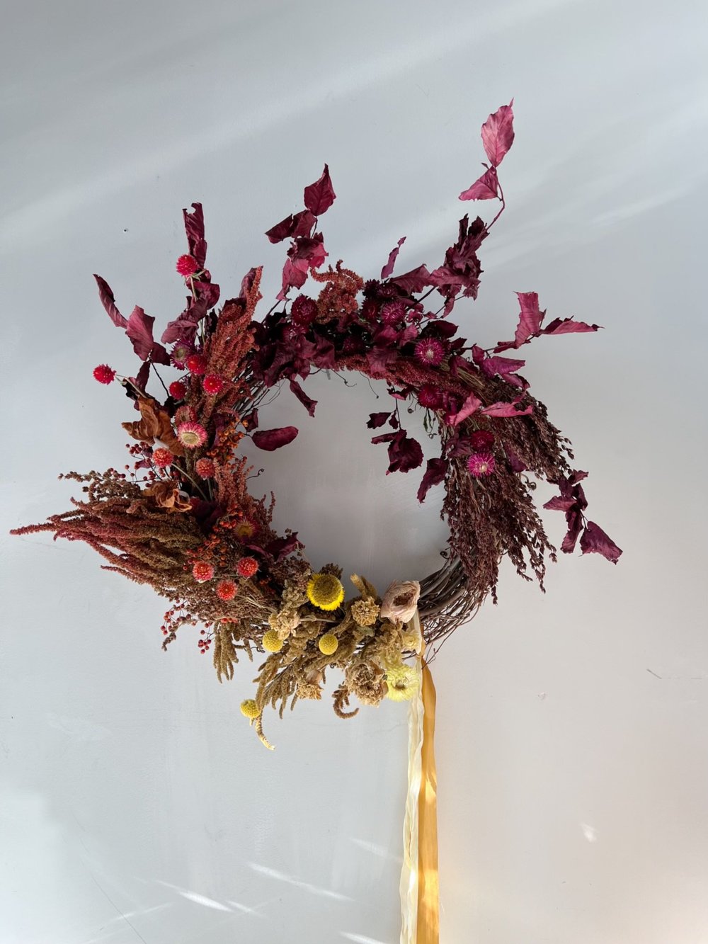 Decorative wreath with dried flowers and berries on a white background
