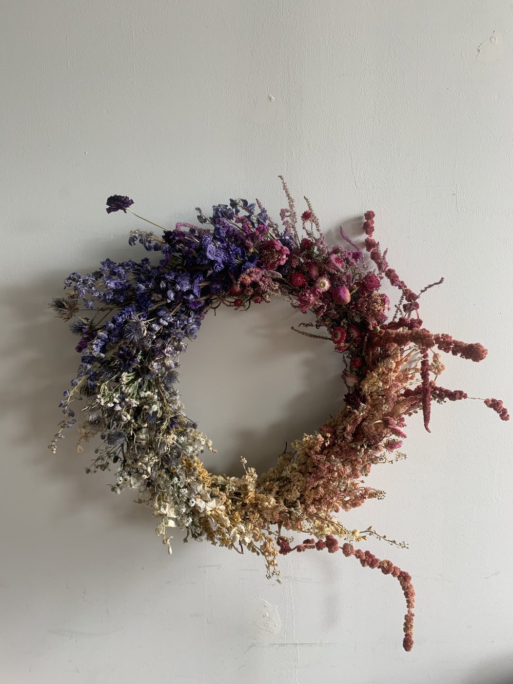 Round dried flower wreath on a plain white wall