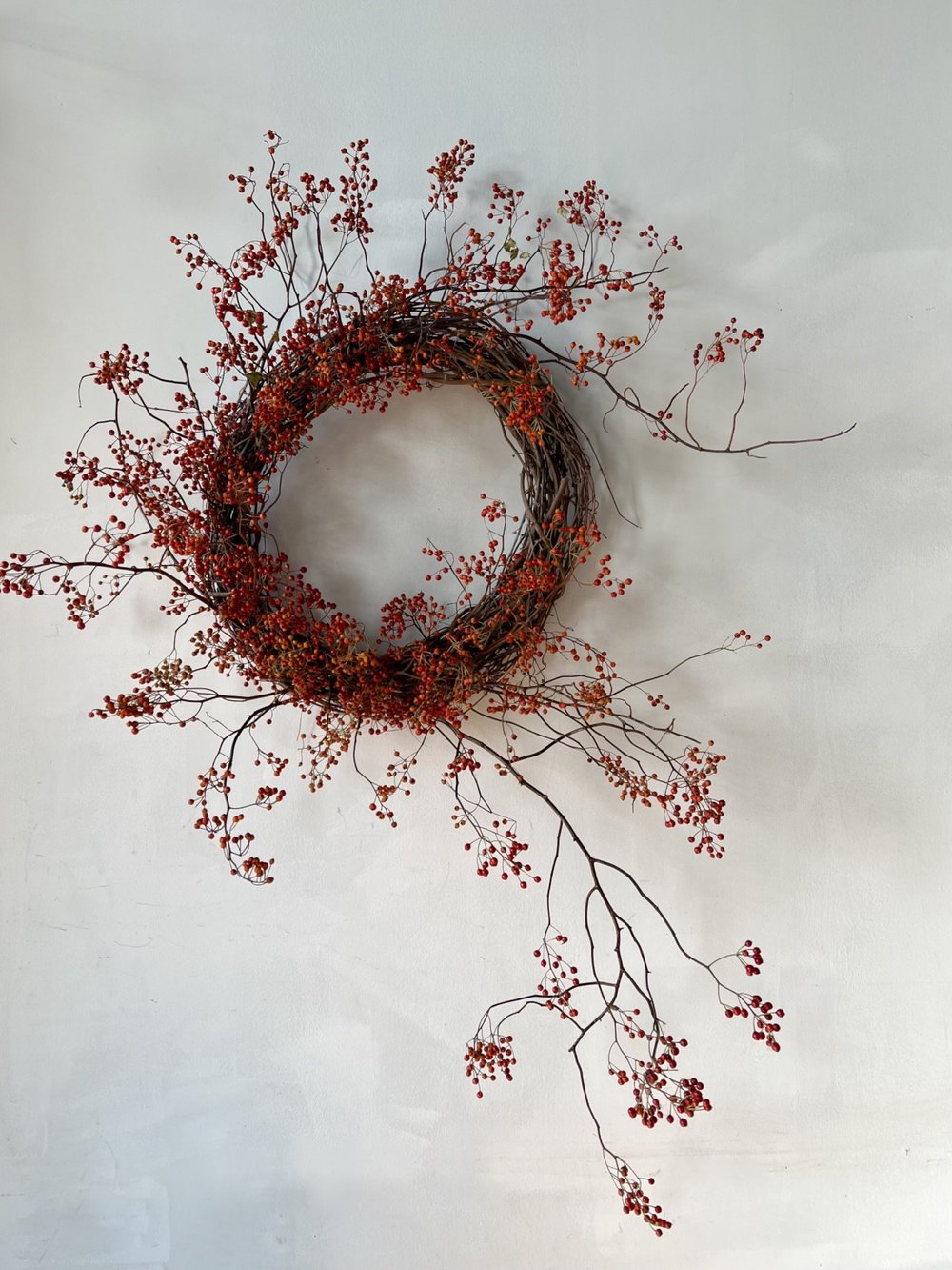 Decorative wreath with red berries on a light gray background
