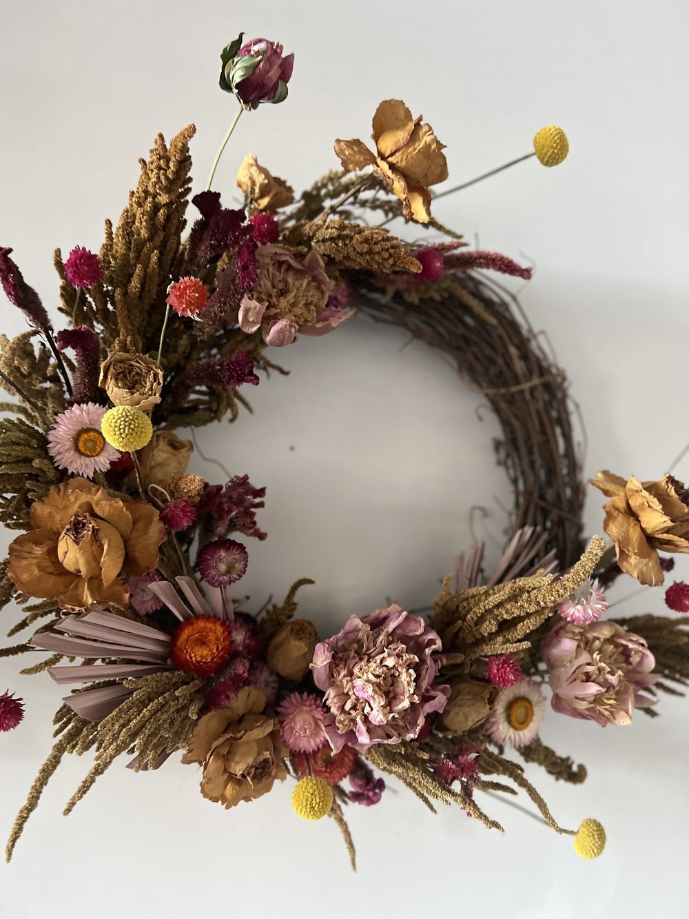 Decorative wreath with dried flowers and herbs on a white background