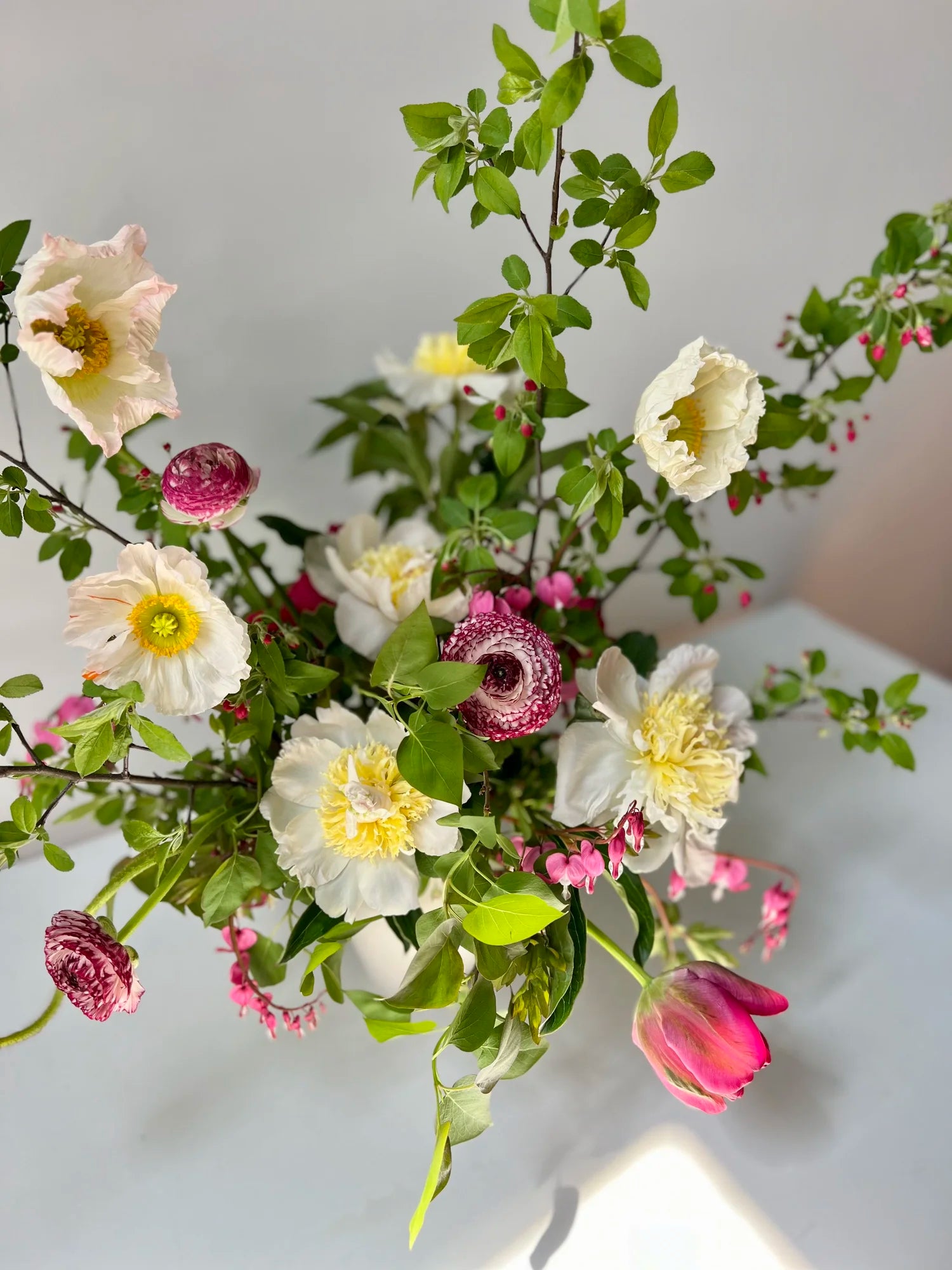Bouquet of flowers with green leaves and pink and white flowers on a light background