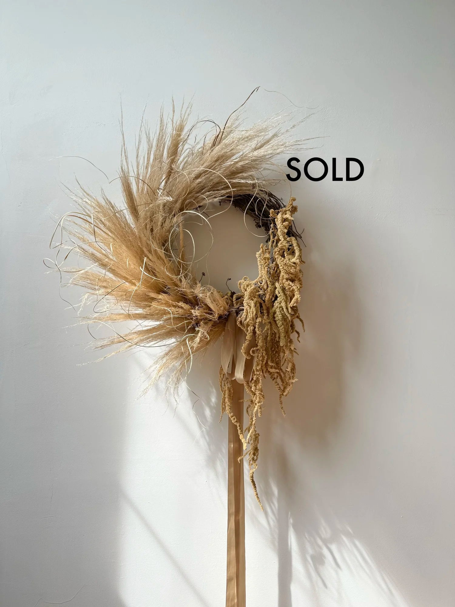 Dried plant wreath on a white background with 'SOLD' text
