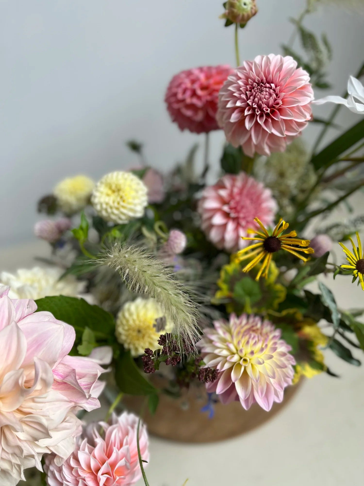 Bouquet of flowers with pink, yellow, and green colors on a light background