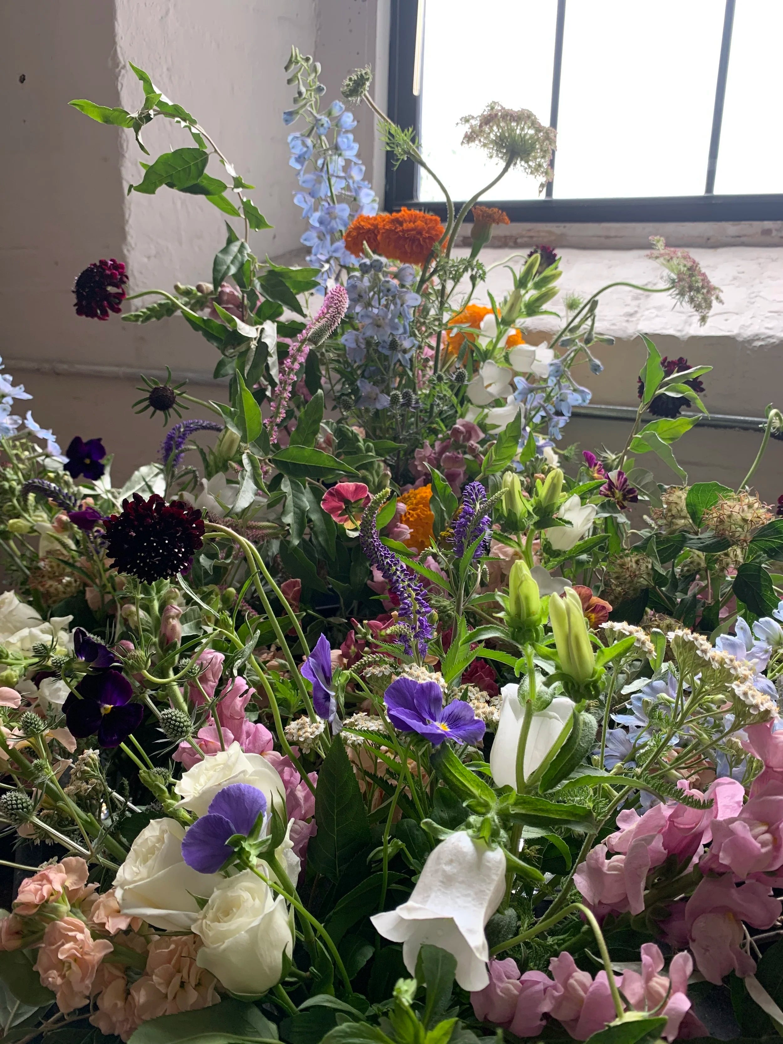 Bouquet of various flowers in a window setting