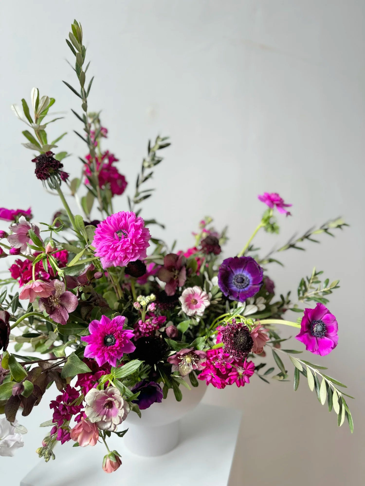 Bouquet of flowers in a white vase on a light gray background