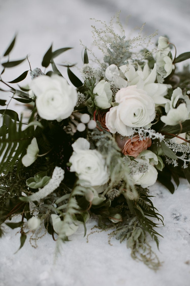 Bouquet of white and pink flowers on a snowy background