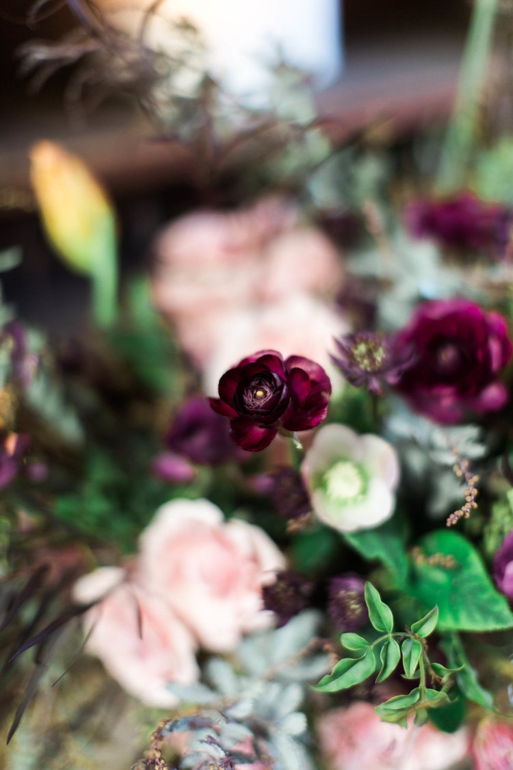 Close-up of a bouquet with purple and pink flowers and green leaves.