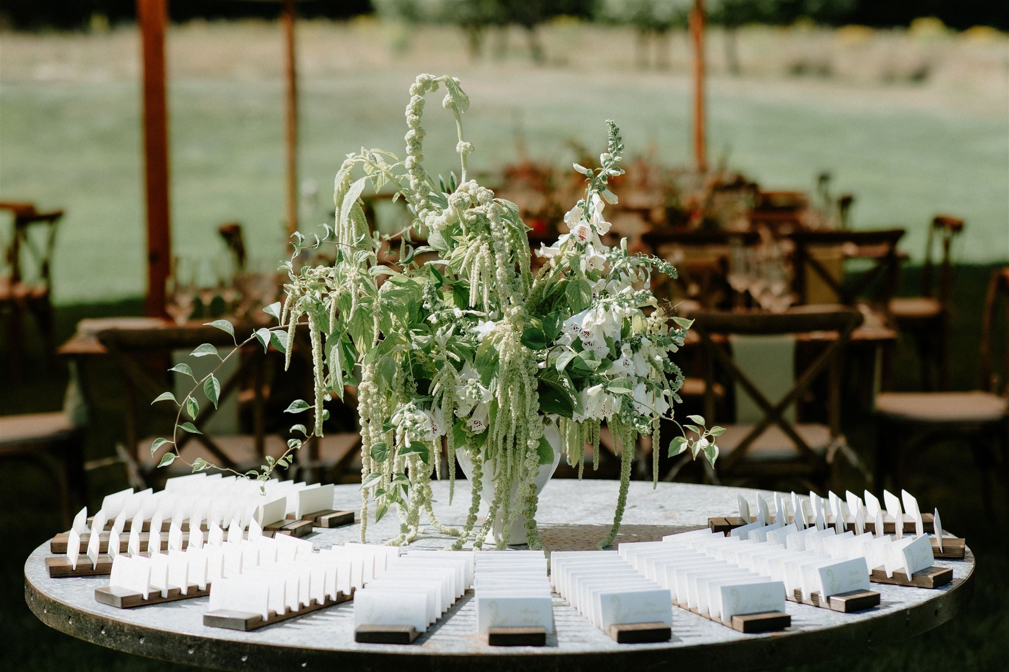 Decorative table setup with floral arrangement and white boxes at an outdoor event.