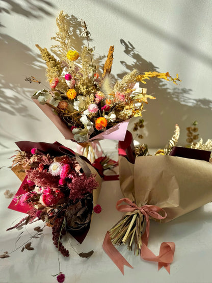 Three bouquets of dried flowers on a light background