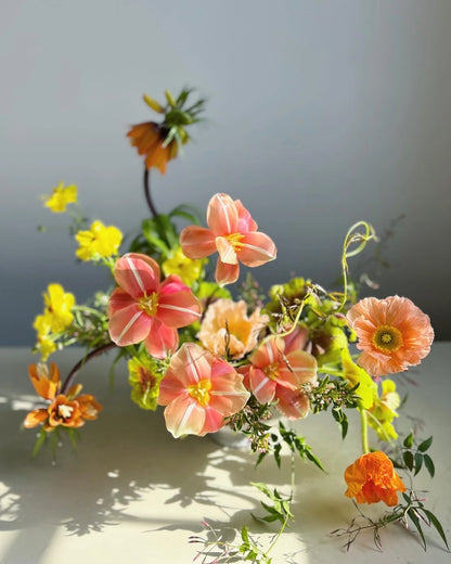 Bouquet of pink, yellow, and orange flowers on a light background