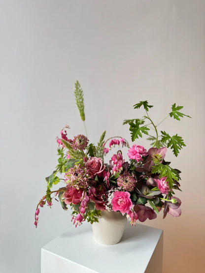 Floral arrangement in a white vase on a light gray background