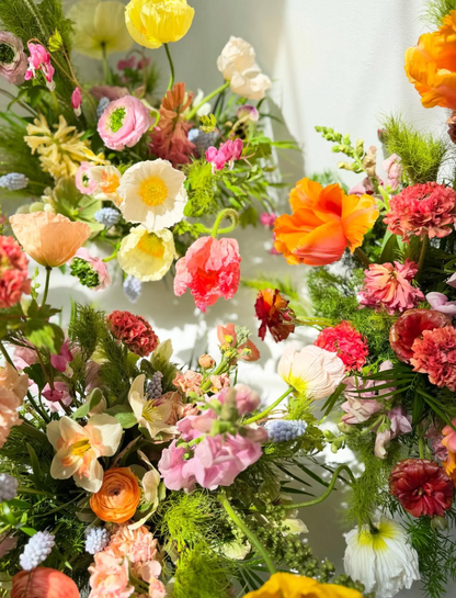 Colorful floral arrangement with various flowers and greenery.