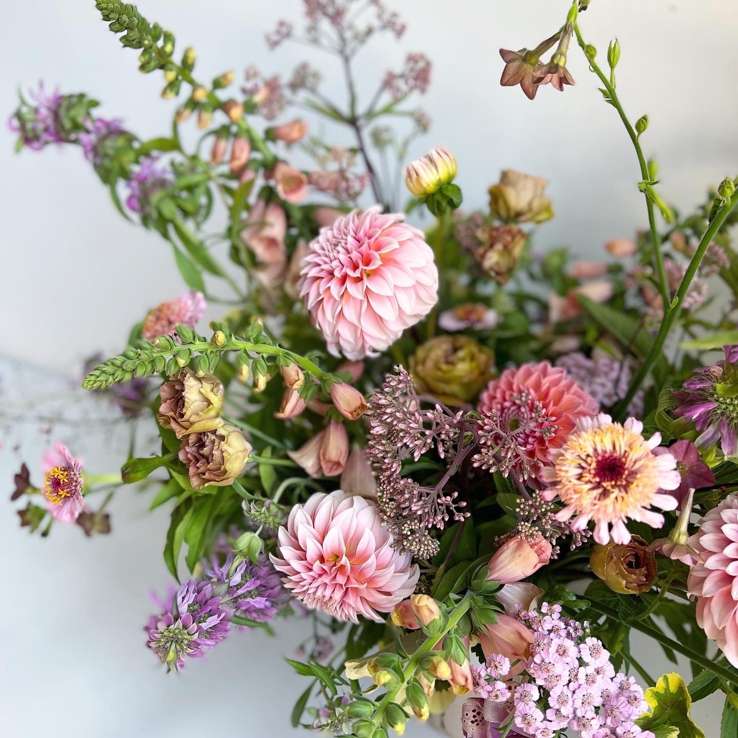 Bouquet of pink, purple, and green flowers on a light background