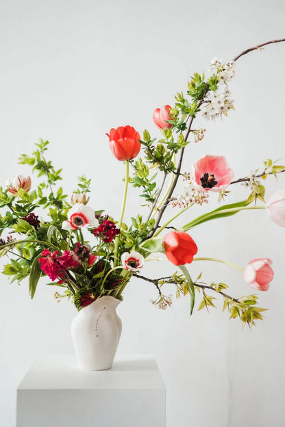 Floral arrangement in a white vase on a light gray background