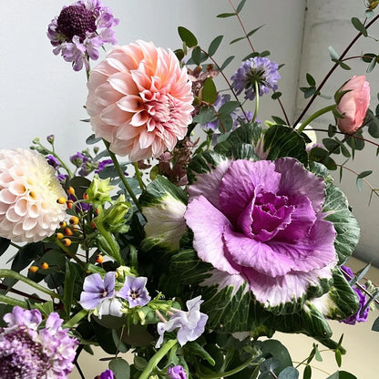 Colorful bouquet of flowers including pink, purple, and green elements.