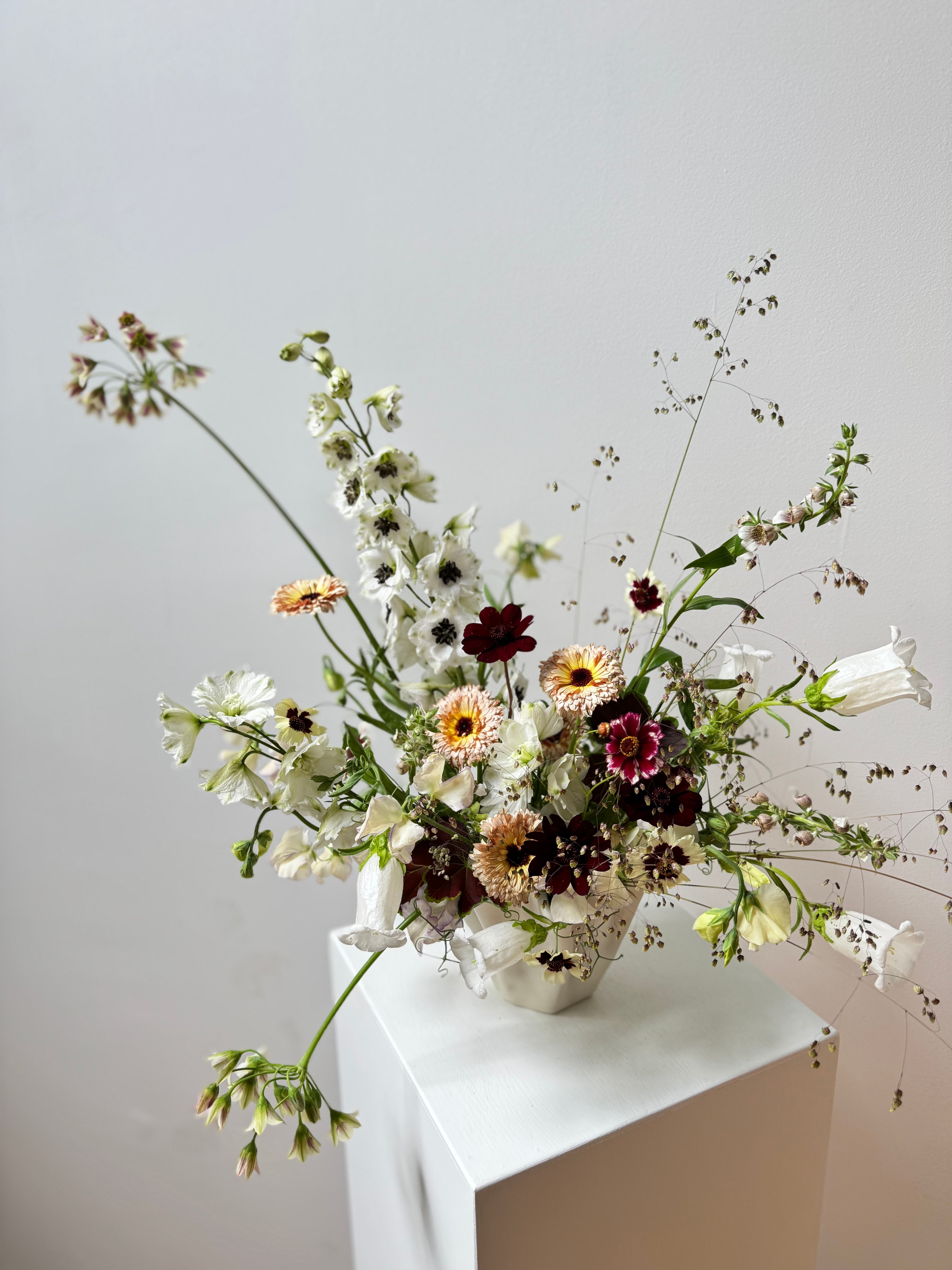 portland miane florist last spring Floral arrangement in a maine maine white vase on a white surface with a light gray background