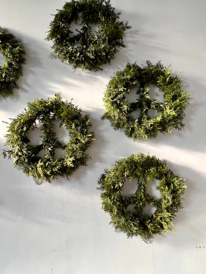 Set of five peace sign shaped green wreaths on a white background