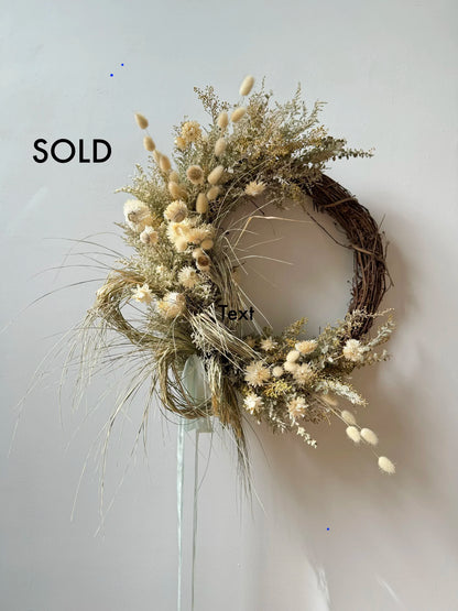 Decorative wreath with dried flowers on a white background, labeled 'SOLD'.
