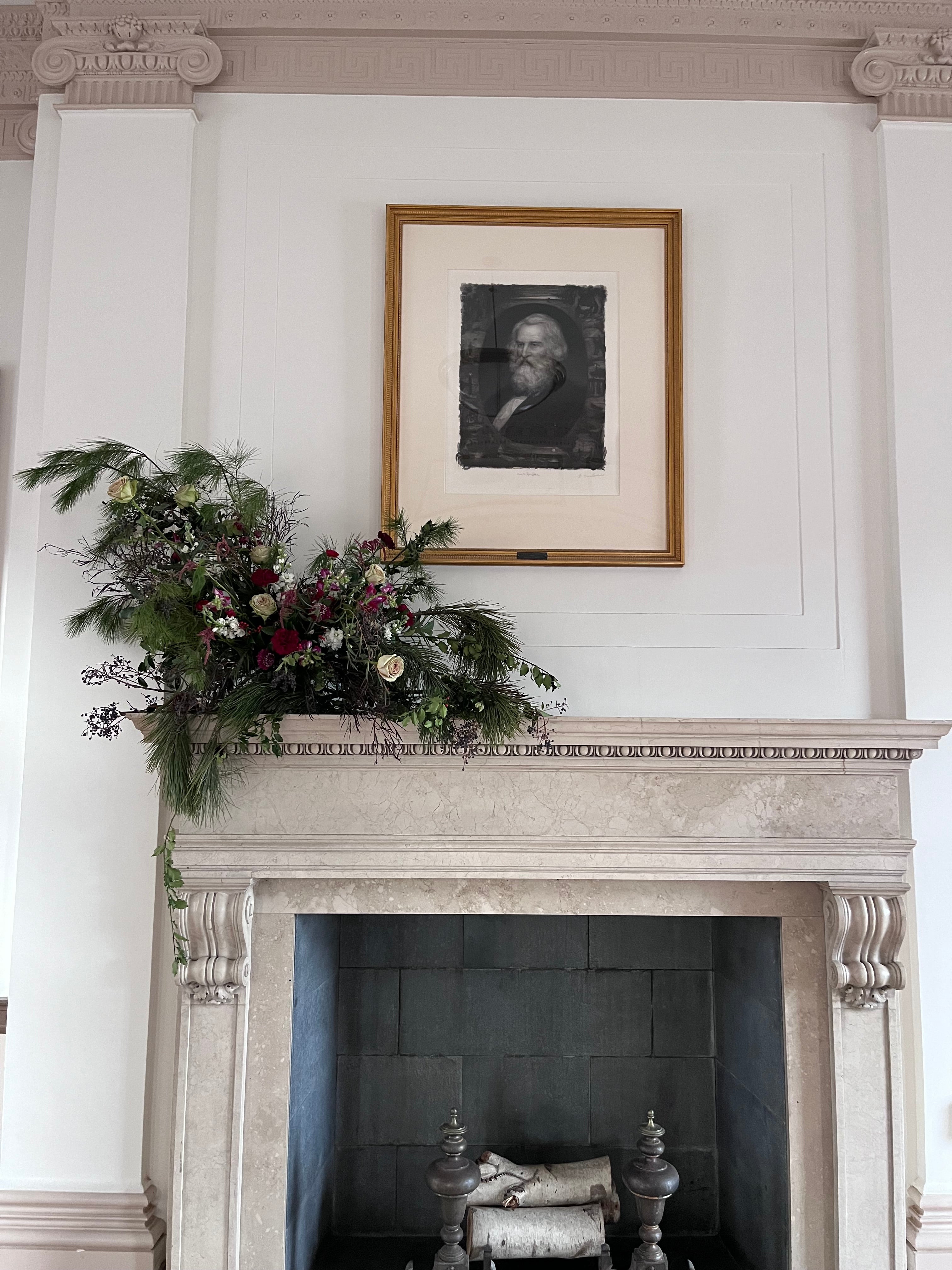 Decorative wreath on a fireplace at the City Hall in Portland Maine under a framed portrait of Henry Longfellow.