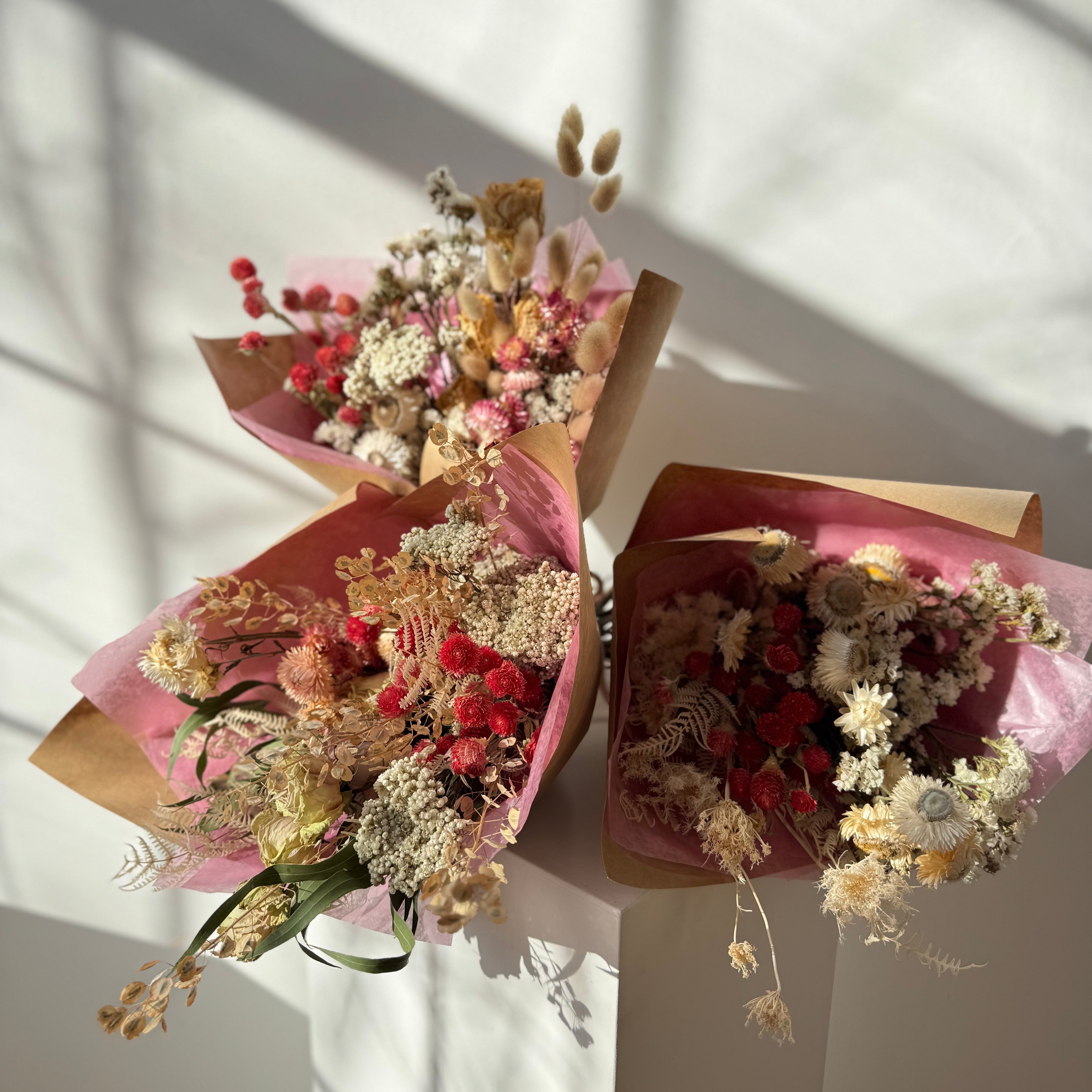Three bouquets of dried flowers wrapped in pink paper for valentines day delivery to falmouth maine
