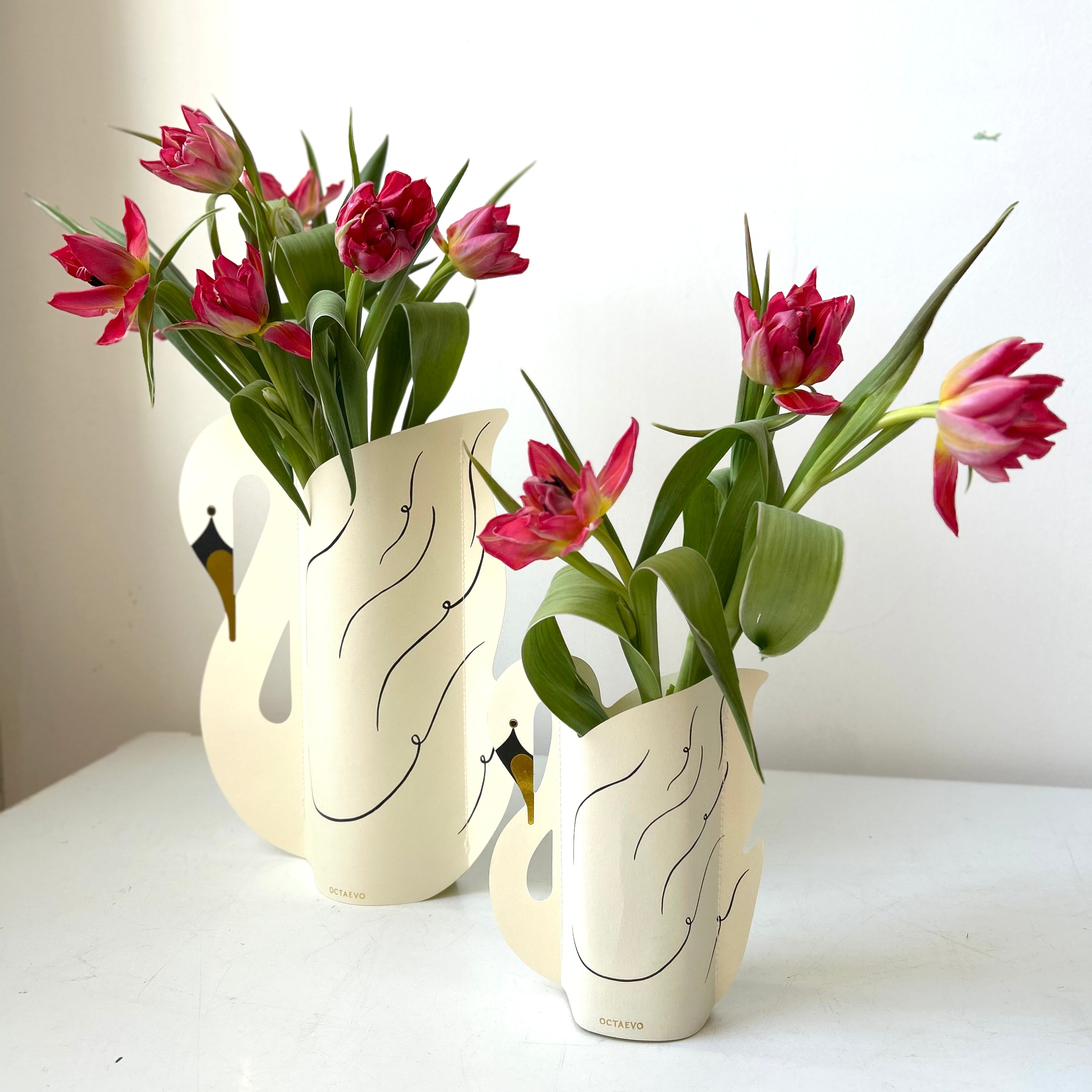tulips arranged in a paper swan vase