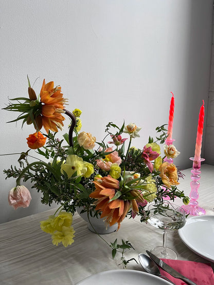 Floral arrangement on a table with candles and cutlery