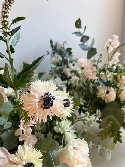 Close-up of a bouquet of flowers with greenery on a white background