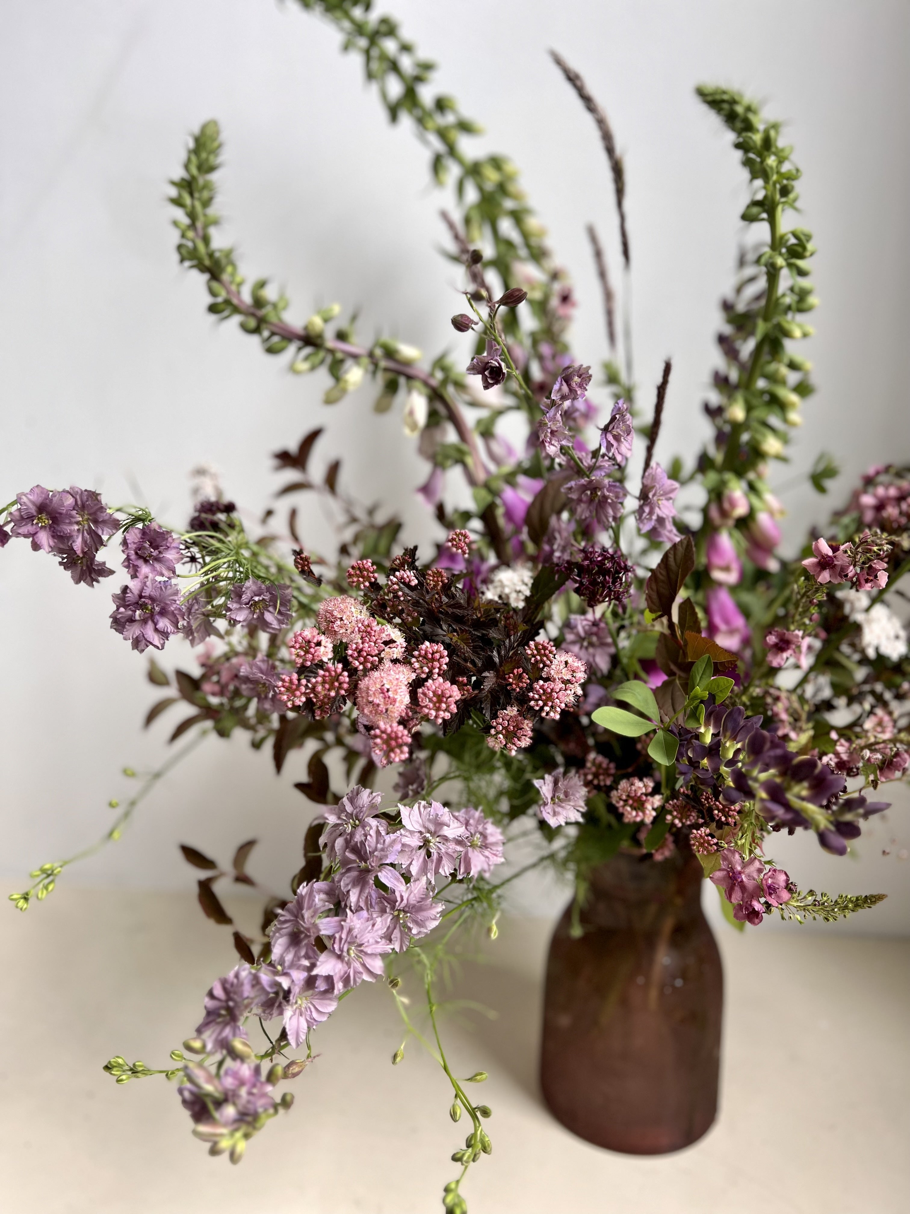 Bouquet of flowers in a brown vase on a light background