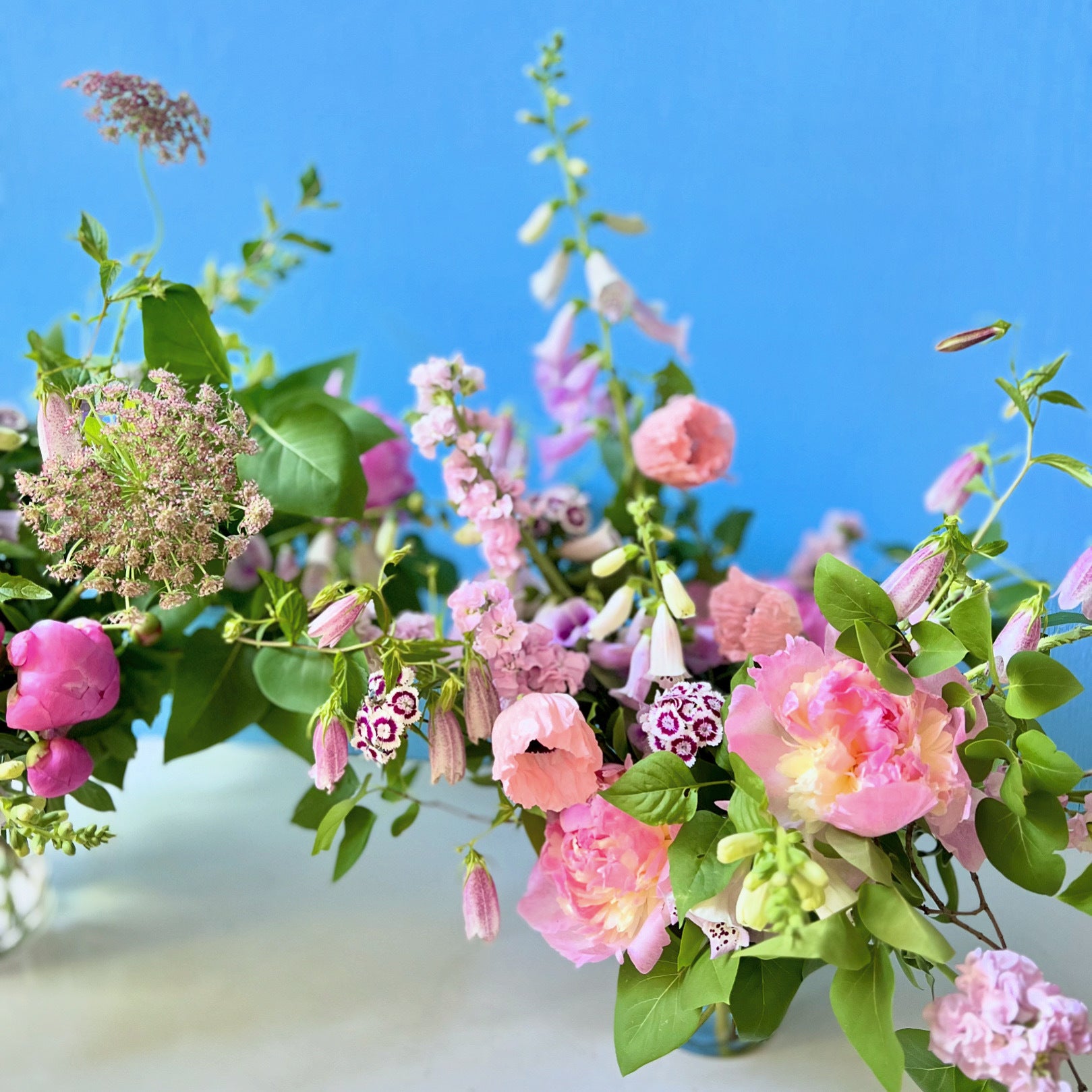 Bouquet of pink and green flowers against a blue sky