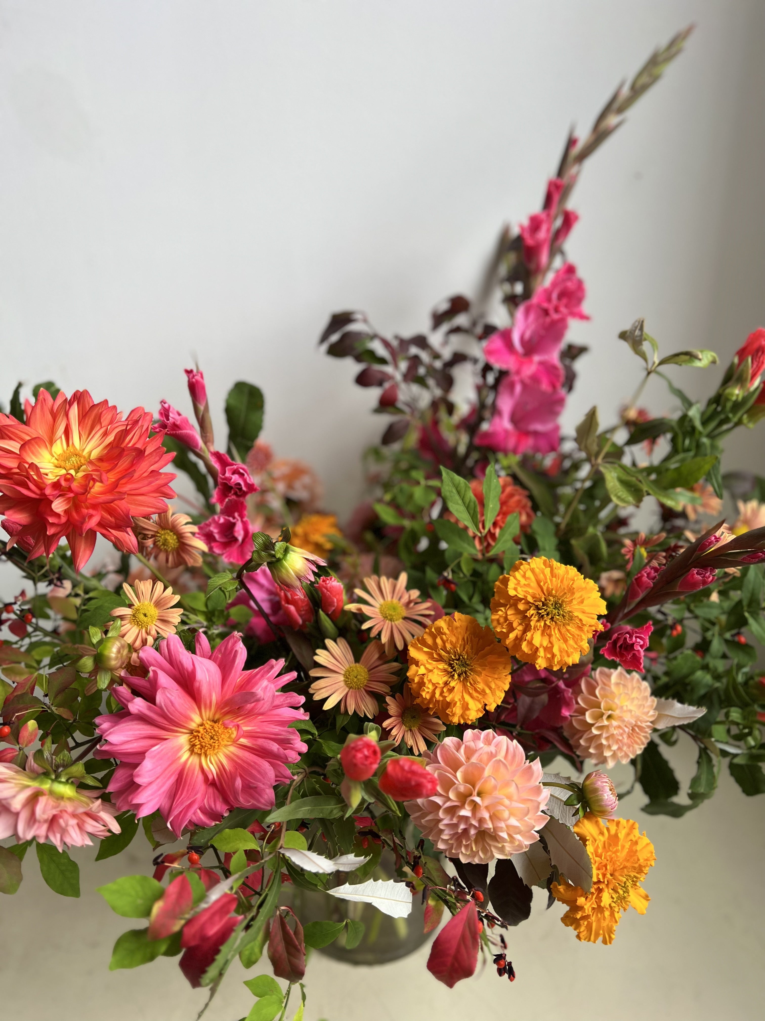 Colorful flower arrangement with pink, orange, and yellow flowers on a white background