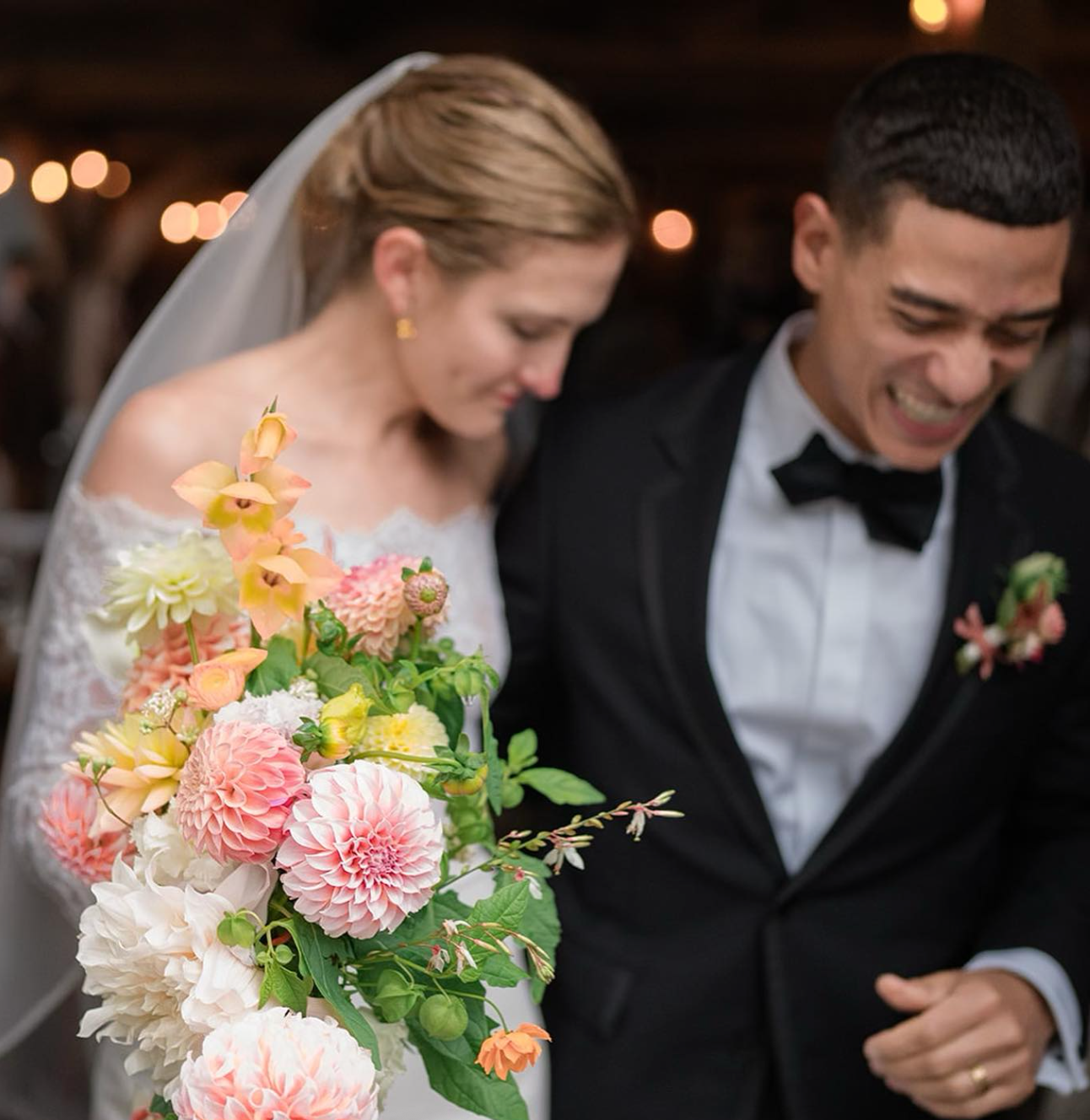 Wedding couple with a colorful bouquet in an indoor setting