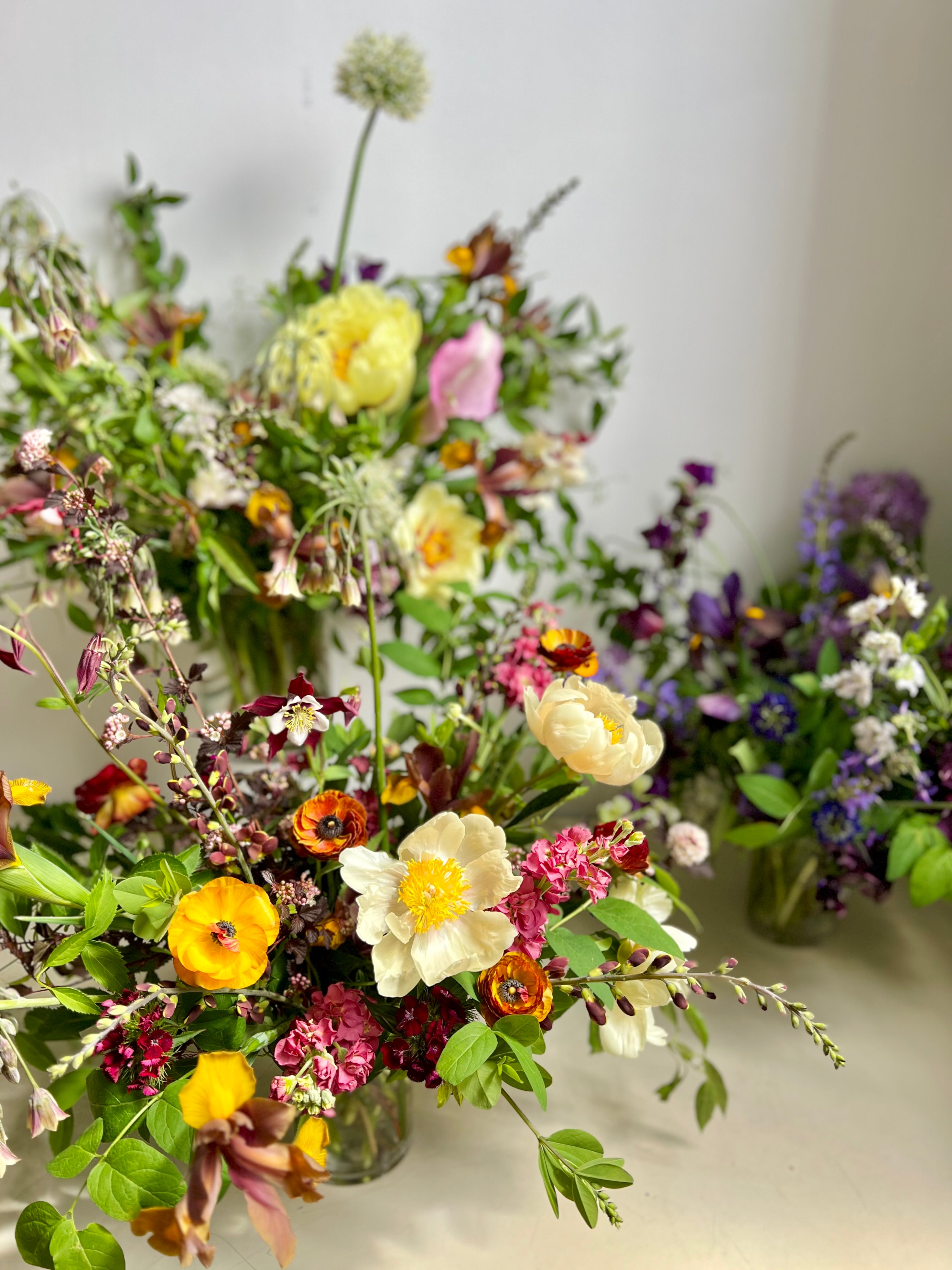 Assortment of colorful floral arrangements on a neutral background from a flower shop in portland maine