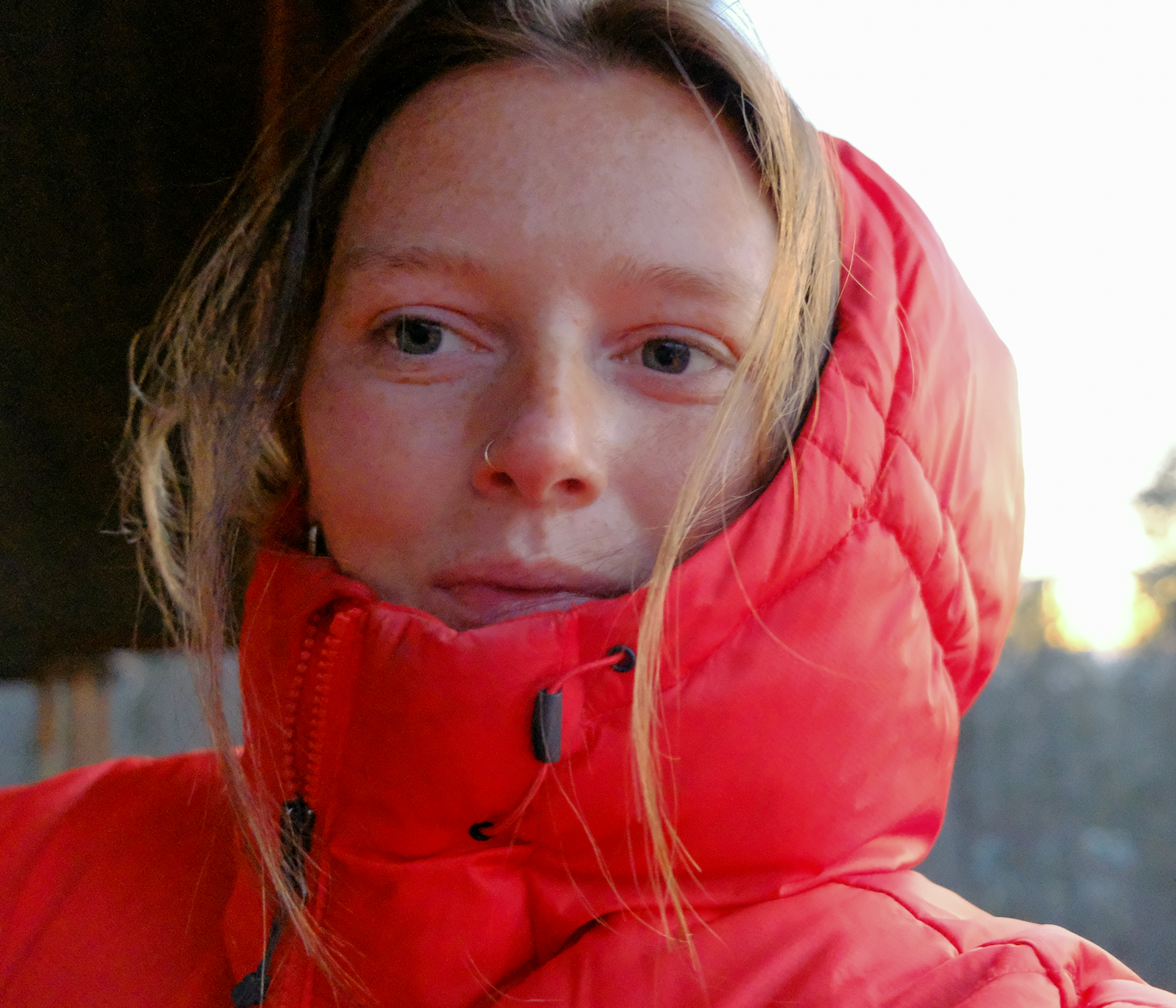 Person wearing a red puffer jacket with a blurred background