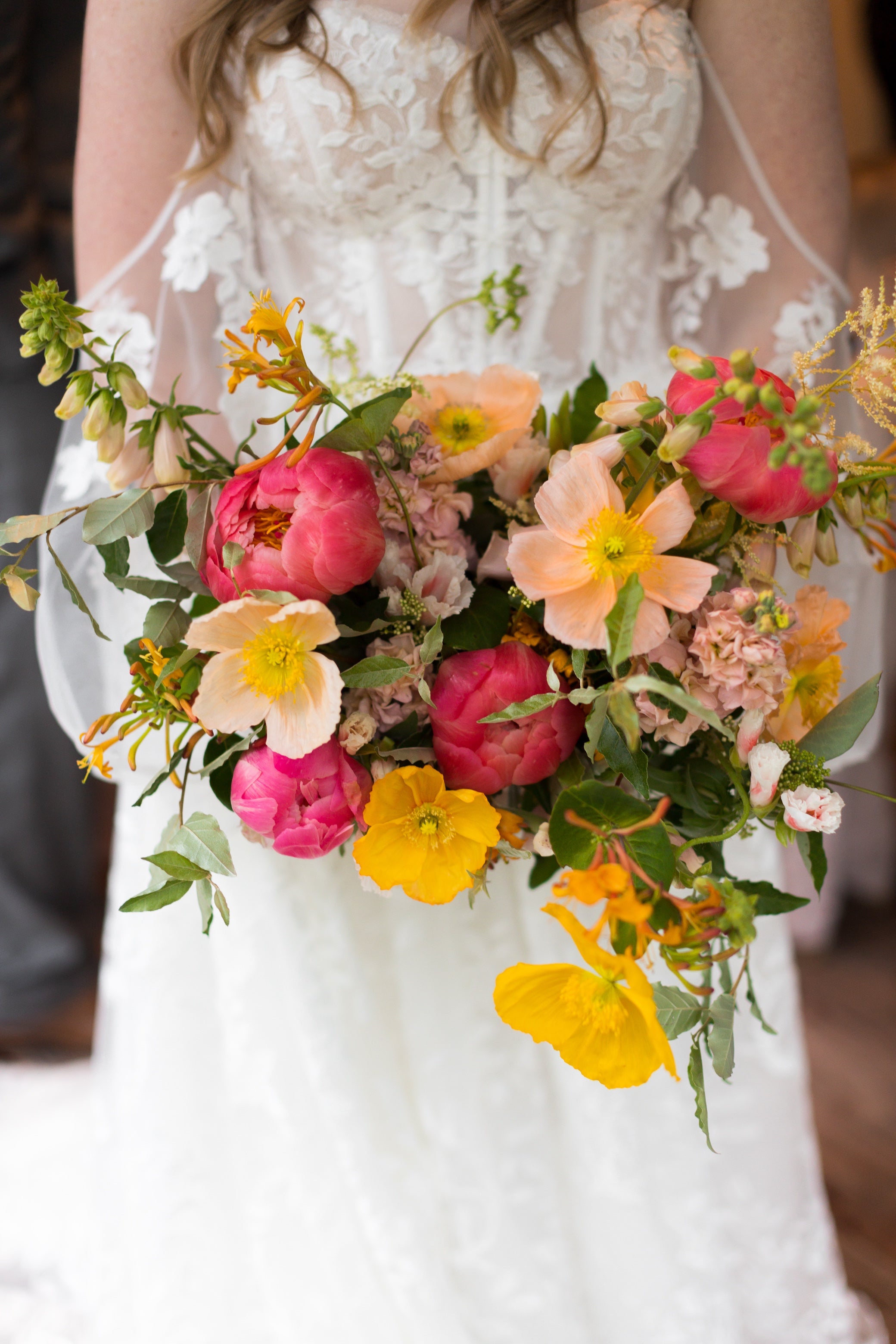 Bouquet of flowers held by a person wearing a white lace dress.