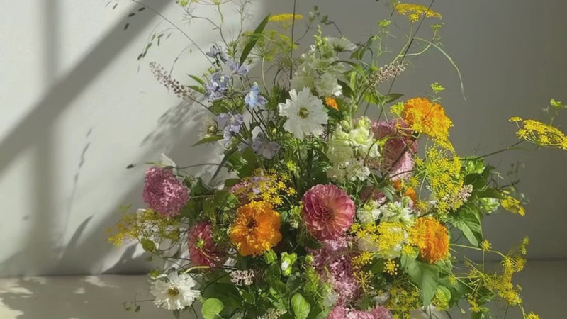 Floral arrangement with various colored flowers with neutral background